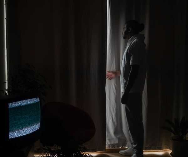 Silhouette of a person stretching against a serene, softly lit background.